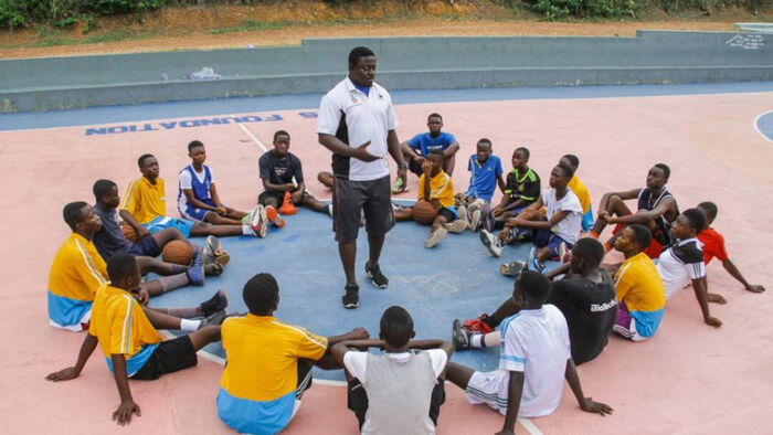 A group of teenage Ghanian footballers listent to their coach
