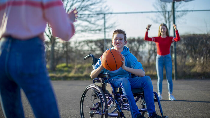Boy in a wheelchair playing basketball