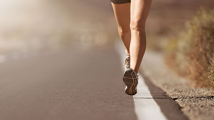En kvinne løper på asfalt