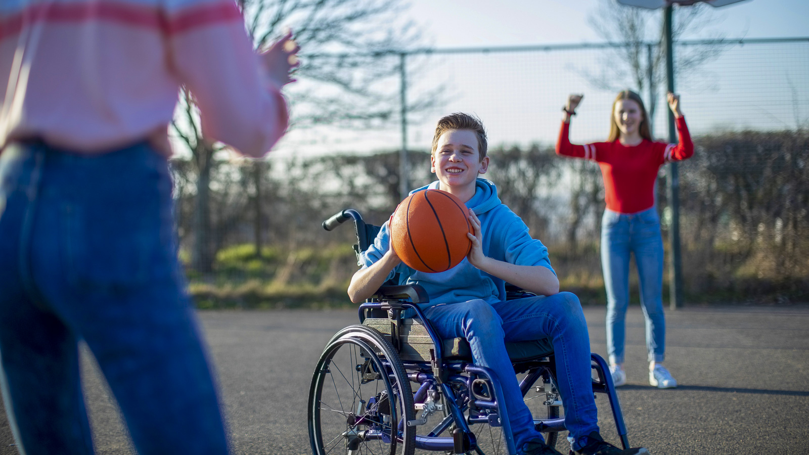 Gutt i rullestol med basketball. 