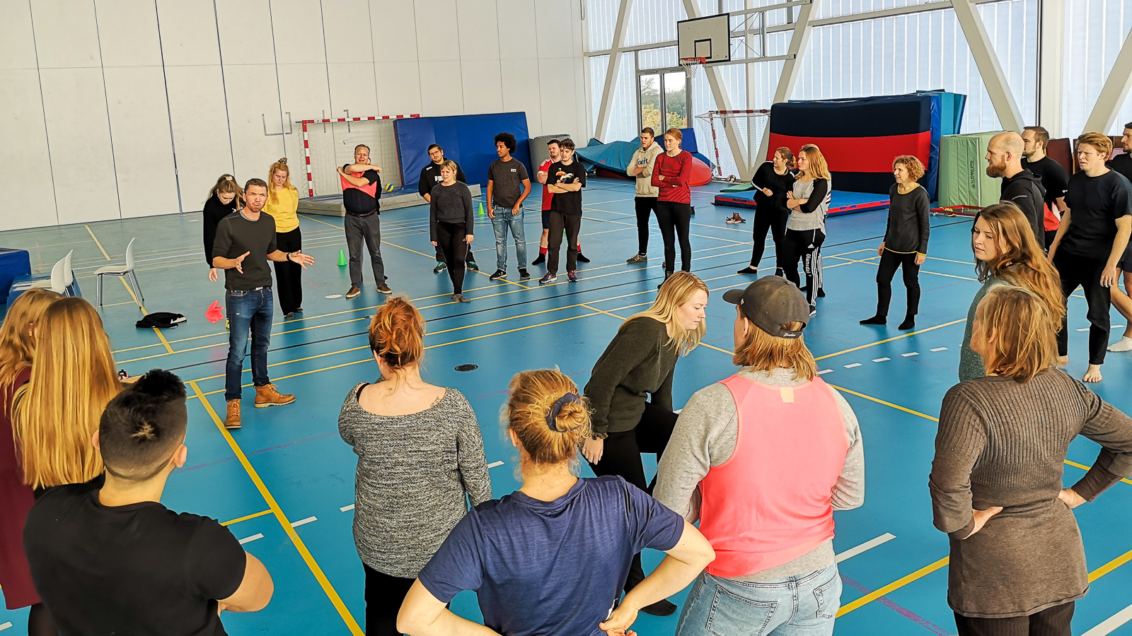 Gruppe ungdommer lærer bevegelse i en gymsal
