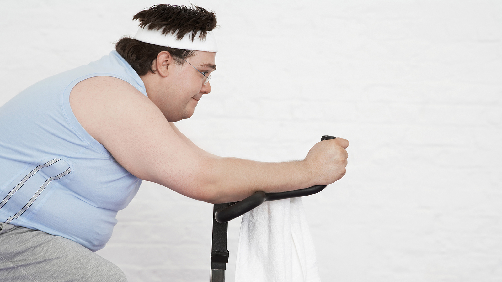 Overvektig mann trener på ergometersykkel