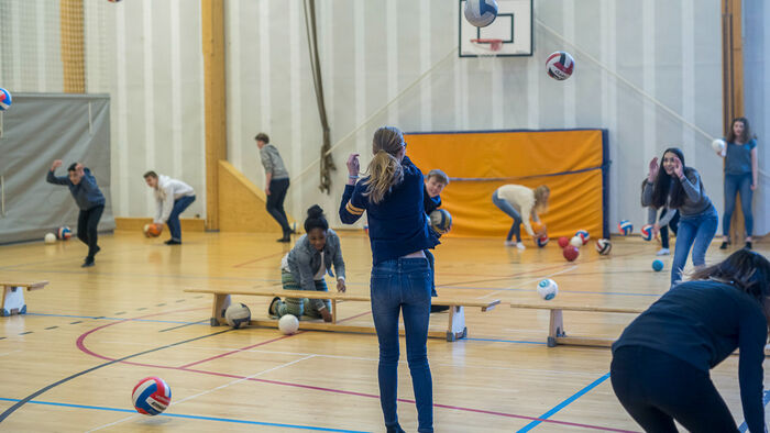 Girls throwing a ball in a gymnasium