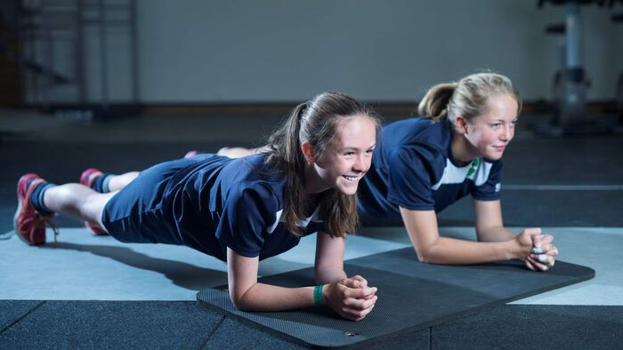 To unge jenter trener planken.