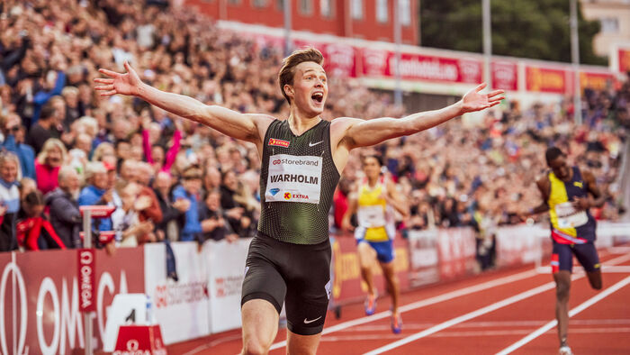Karsten Warholm raising his arms in the air after another win on the running track