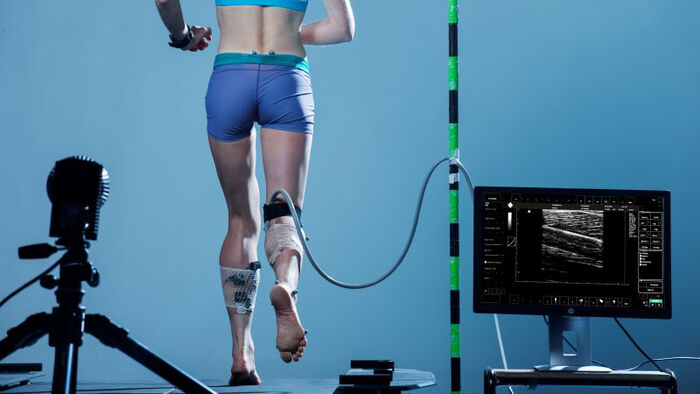 Women runs with an ultrasound receiver connected to her leg