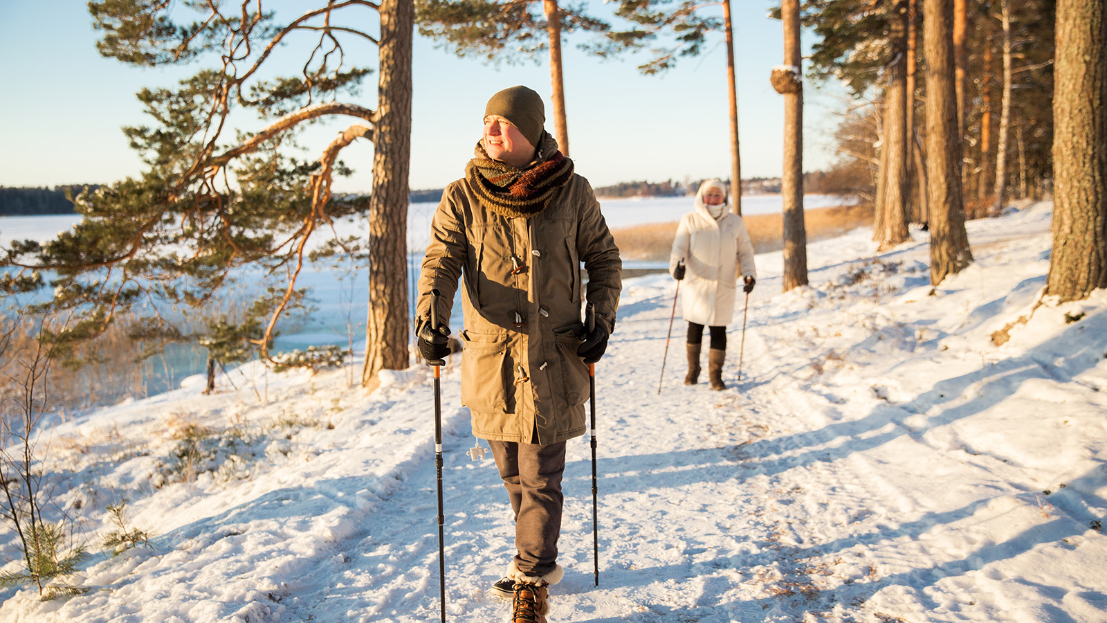 Mann og kvinne går en tur i skogen om vinter