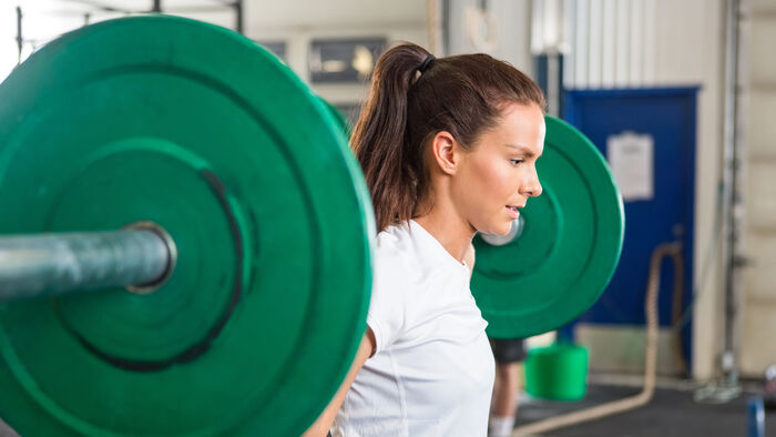 Ung kvinne trener styrke med vekter