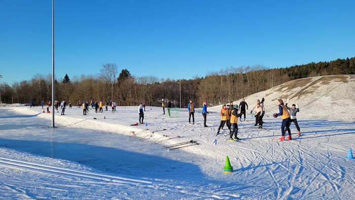 NIH studenter spiller fotball på ski som oppvarming og lek.