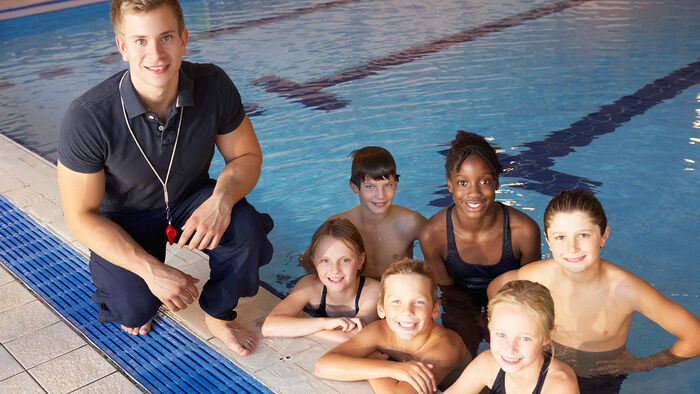Gruppe bilde av svømmecoach og unge utøvere