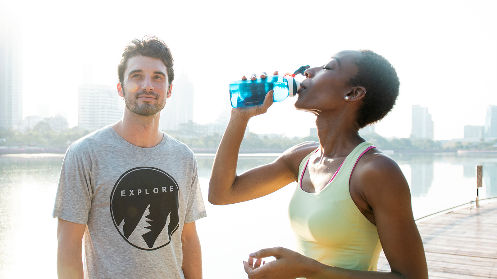 En mann og en kvinne drikker vann før treningsøkten starter. 