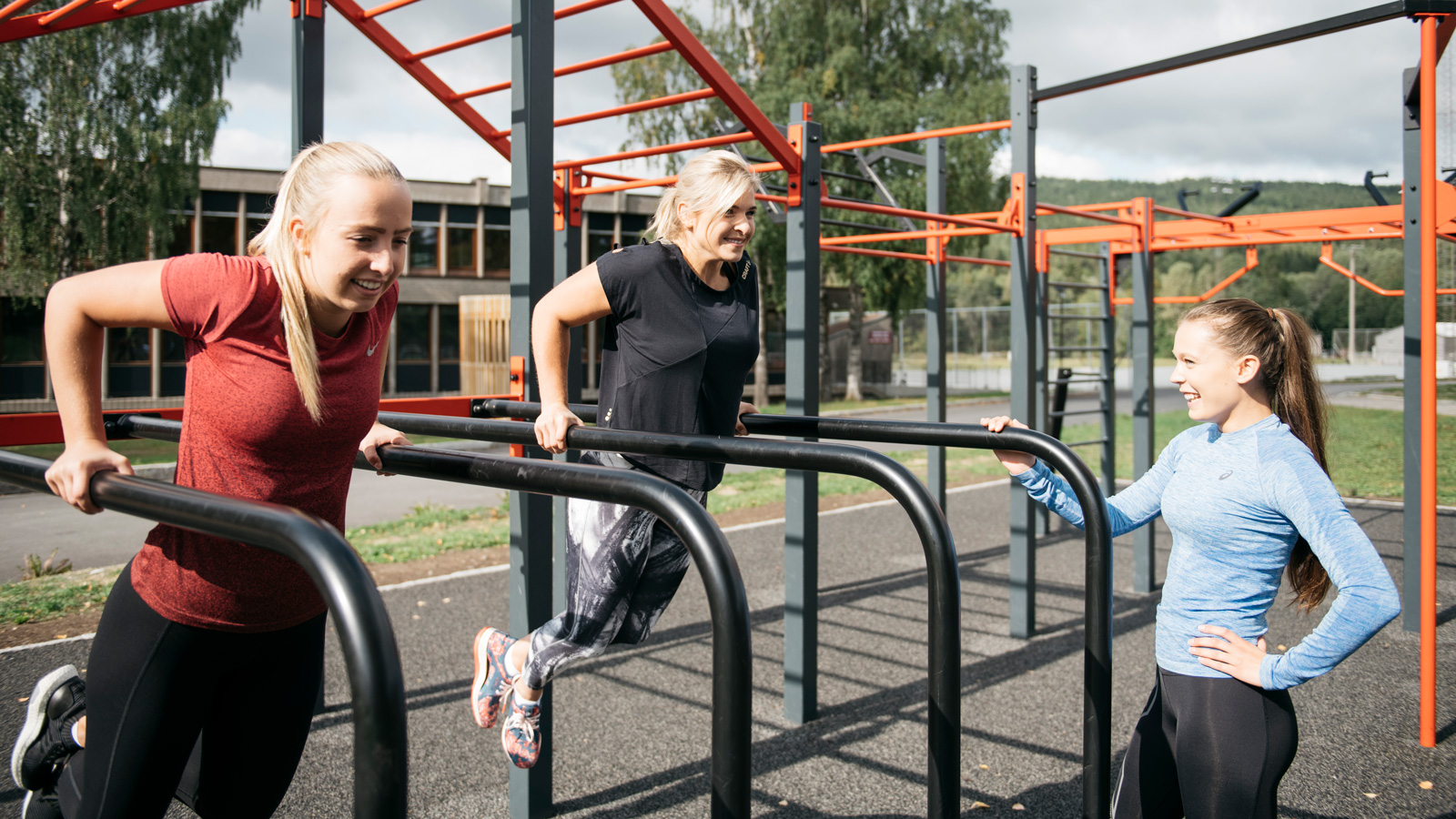 Tre jenter trener styrketrening i utetreningspark