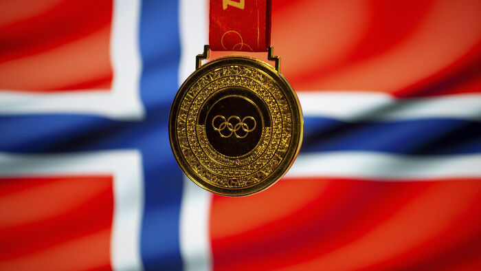 Gullmedalje foran norsk flagg