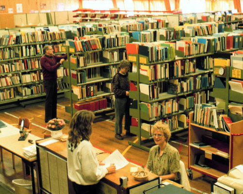 Interiør av biblioteket med reoler av bøker og skranken