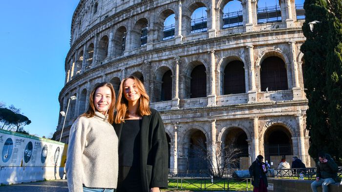  To norske studenter smiler til kamera foran Colosseum i Roma.  
